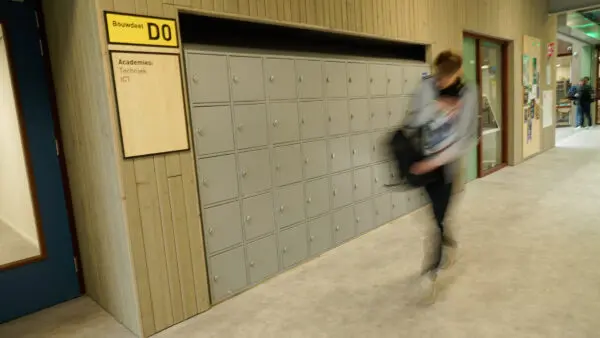 Een student loopt langs de kluisjes