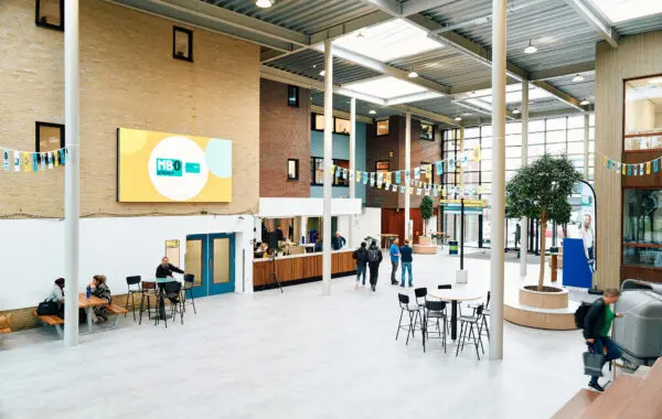 Mbo-studenten en bezoekers bewegen zich vlakbij de ingang van de Onderwijsboulevard
