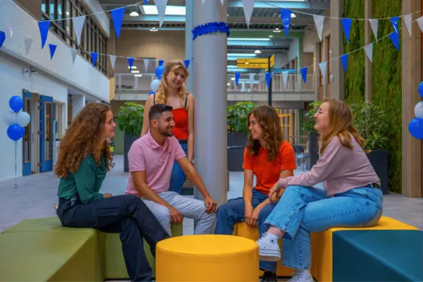 Groep studenten overlegd in een feestelijk gedeelte van de kantine