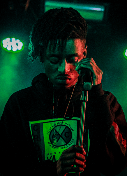 HBA-student hiphop op het podium achter een microfoon