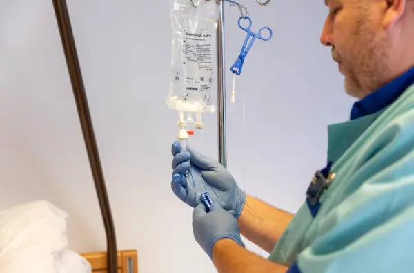 Student Verpleegkundige volwassenenonderwijs in een praktijksetting oefent met infuus
