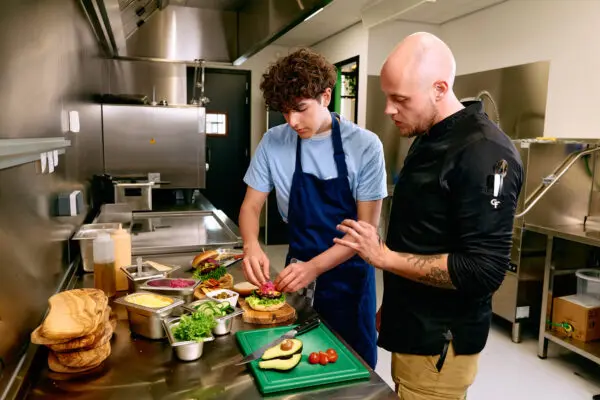 Horeca student krijgt instructie van een kok