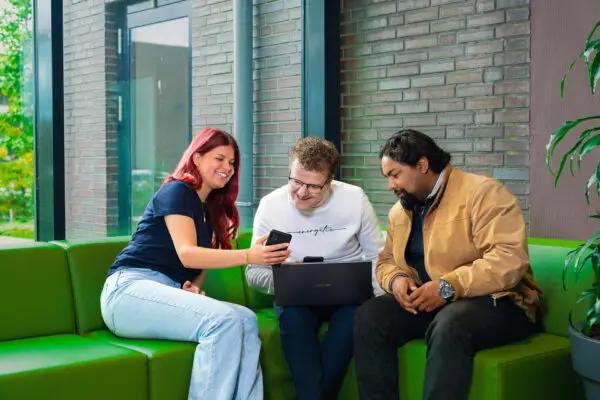 Studenten en docent op groene bankjes in de gangen van MBO Utrecht