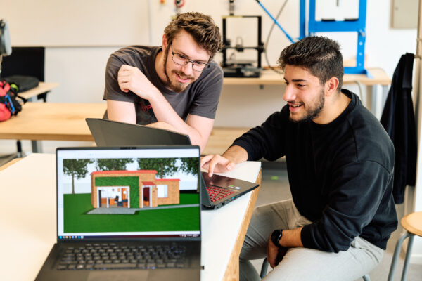 Twee MBO-studenten Bouw bekijken op hun laptop technische ontwerptekeningen