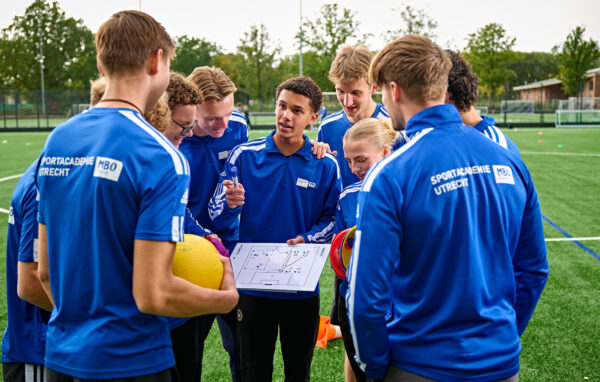 Mbo studenten sport krijgen buiten op het sportveld instructie