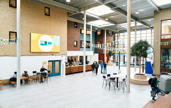 Mbo-studenten en bezoekers bewegen zich vlakbij de ingang van de Onderwijsboulevard