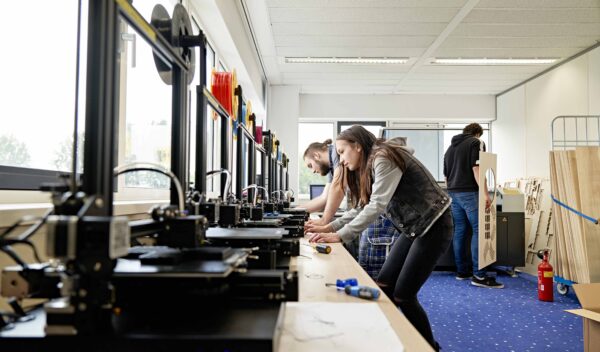 mbo-studenten technicus engineering staan bij rijtje 3d printers