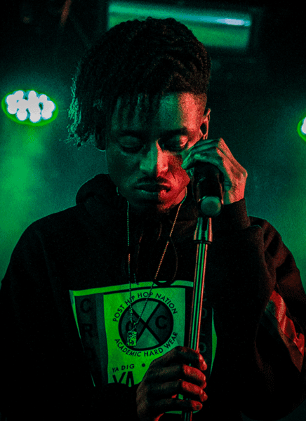 HBA-student hiphop op het podium achter een microfoon