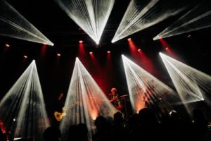 Artiesten op een podium met witte lichtshow